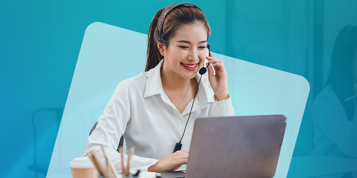 A virtual receptionist smiles at a laptop while speaking into a headset